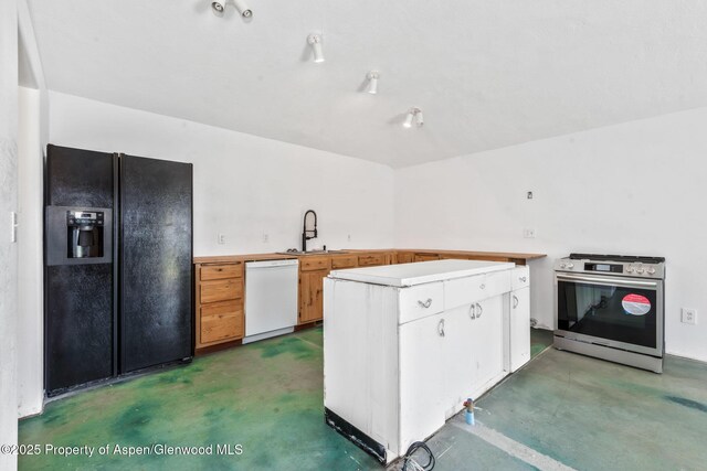 40889 County Road 76a, Hayden, CO 81639 - kitchen featuring black fridge, stainless steel range with gas stovetop, a sink, dishwasher, and concrete flooring