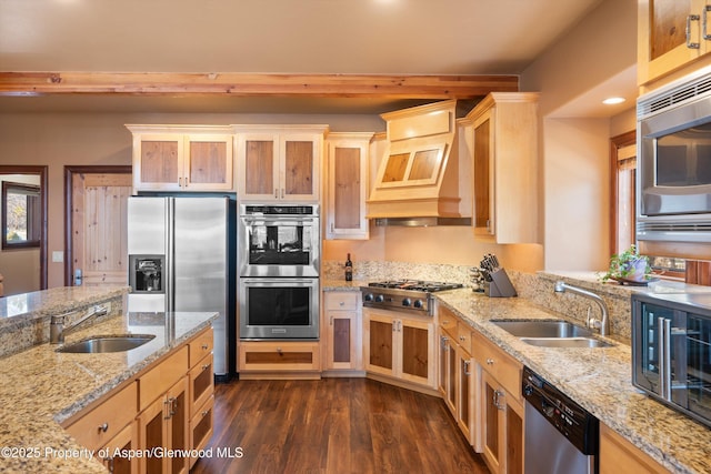 kitchen featuring custom exhaust hood, stainless steel appliances, a sink, and light brown cabinetry