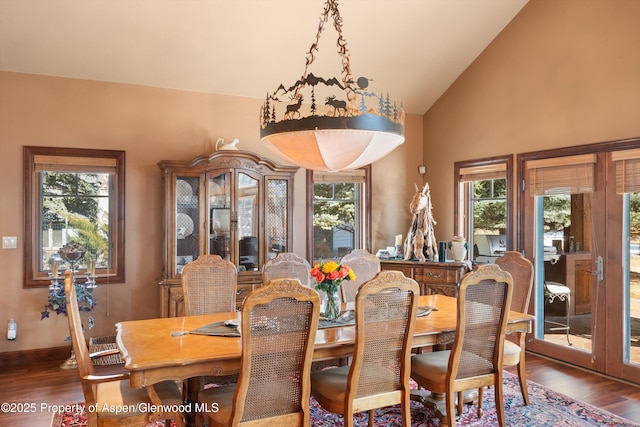 dining space with high vaulted ceiling, a wealth of natural light, and wood finished floors