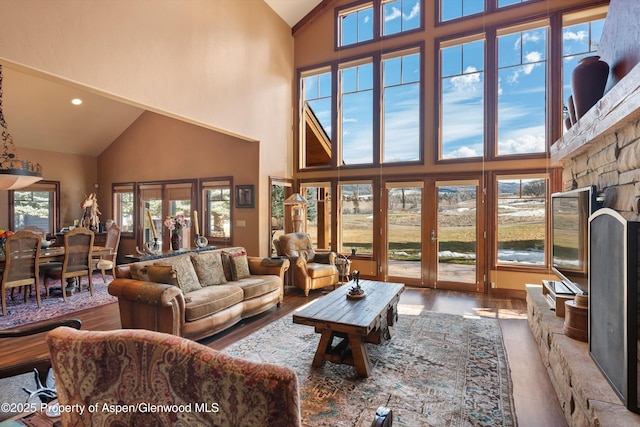 living room with high vaulted ceiling, recessed lighting, and wood finished floors