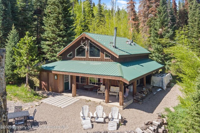 0 E Divide Creek Rd, Silt, CO 81652 - rear view of house with metal roof, a patio area, and a wooded view