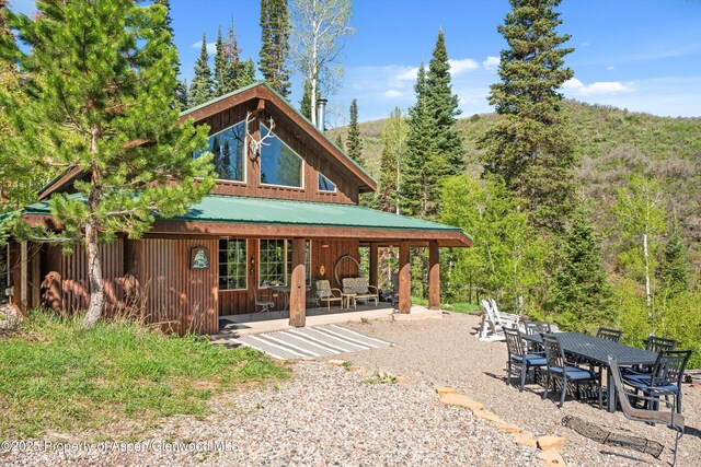 0 E Divide Creek Rd, Silt, CO 81652 - rear view of property with a patio, metal roof, a forest view, and outdoor dining space