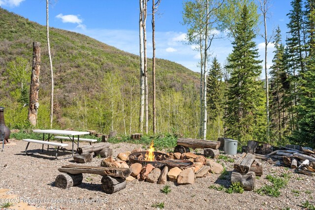 0 E Divide Creek Rd, Silt, CO 81652 - view of yard featuring an outdoor fire pit, a mountain view, and a view of trees