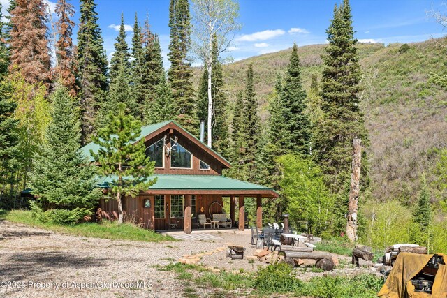 0 E Divide Creek Rd, Silt, CO 81652 - back of house featuring a view of trees, a patio area, and metal roof