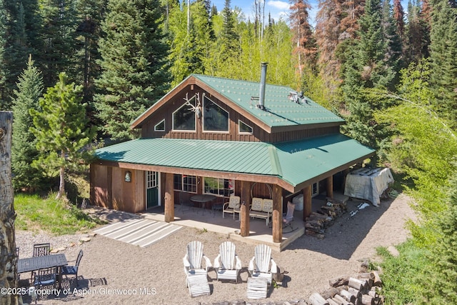 0 E Divide Creek Rd, Silt, CO 81652 - rear view of house with metal roof, a patio area, and a wooded view