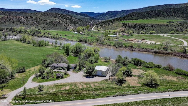 drone / aerial view with a water and mountain view and a rural view