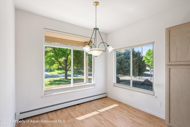 55 Limberpine Cir, Battlement Mesa, CO 81635 - unfurnished dining area with a baseboard radiator, plenty of natural light, a chandelier, and wood finished floors