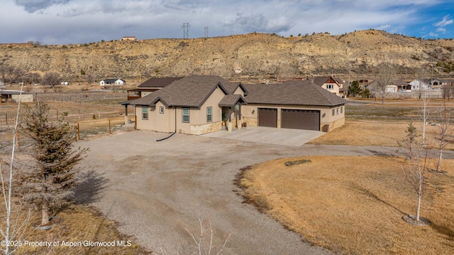 view of front of house featuring a garage, driveway, fence, and stucco siding