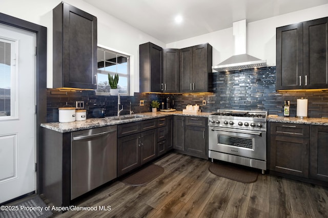 kitchen with wall chimney range hood, dark wood-type flooring, stainless steel appliances, and a sink