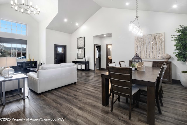 dining space with high vaulted ceiling, a chandelier, and dark wood-style flooring