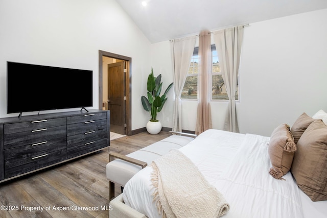 bedroom featuring vaulted ceiling, wood finished floors, and baseboards