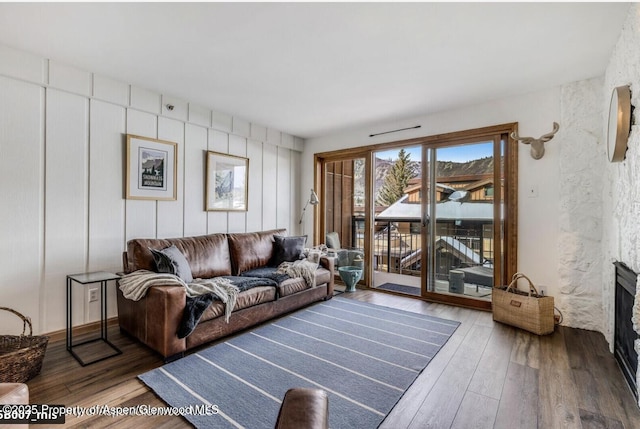 living area with a large fireplace and wood-type flooring