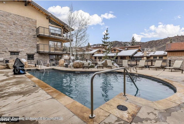 community pool with a patio area and fence