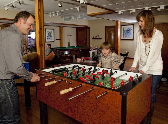 playroom featuring dark wood-type flooring, track lighting, and billiards