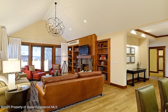 living room with french doors, a stone fireplace, a chandelier, built in features, and light hardwood / wood-style floors