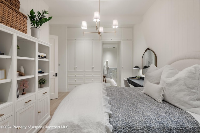 bedroom featuring light hardwood / wood-style flooring and an inviting chandelier