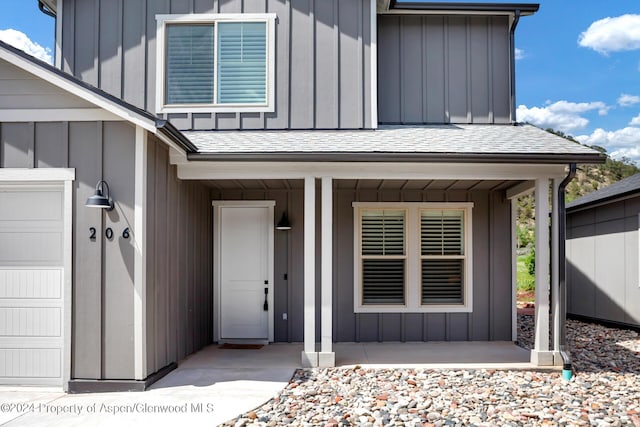 property entrance featuring covered porch and a garage