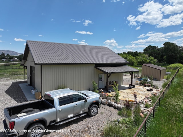 6398 County Road 4, Meeker, CO 81641 - view of front facade featuring a metal roof, a mountain view, a patio, and an outbuilding