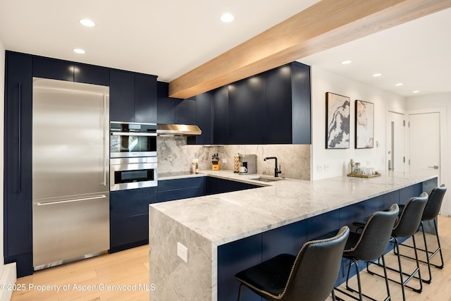 800 S Mill St Unit 304D, Aspen, CO 81611 - kitchen with a peninsula, a sink, appliances with stainless steel finishes, dark cabinetry, and recessed lighting