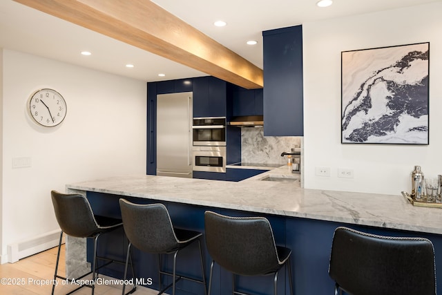 800 S Mill St Unit 304D, Aspen, CO 81611 - kitchen featuring stainless steel appliances, light stone countertops, decorative backsplash, blue cabinetry, and recessed lighting