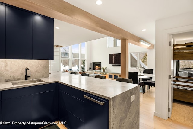 800 S Mill St Unit 304D, Aspen, CO 81611 - kitchen with a sink, light stone countertops, a lit fireplace, and modern cabinets