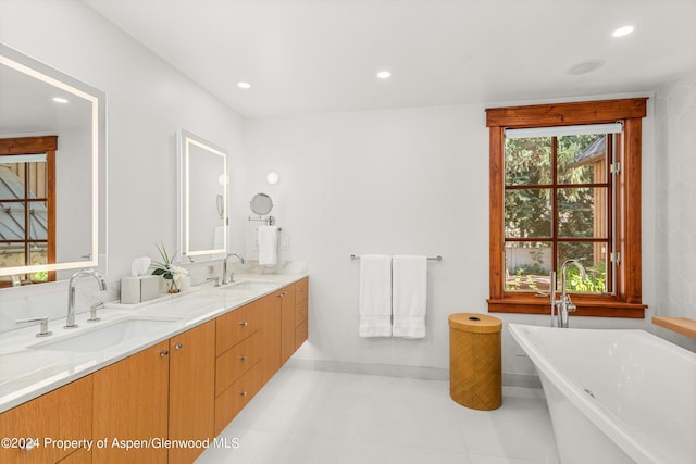 bathroom featuring a tub to relax in, a healthy amount of sunlight, and vanity