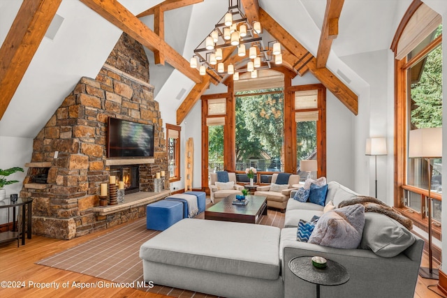 living room featuring wood-type flooring, a stone fireplace, a notable chandelier, high vaulted ceiling, and beam ceiling