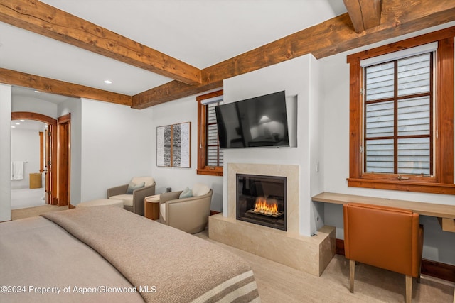 bedroom with beam ceiling and a fireplace