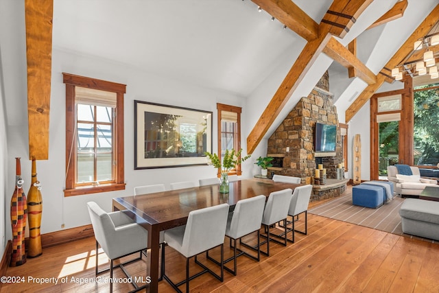 dining room featuring plenty of natural light, beam ceiling, and a fireplace