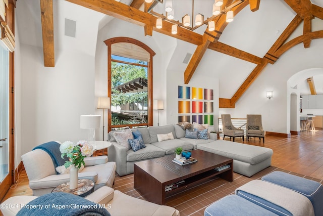 living room with an inviting chandelier, beam ceiling, and high vaulted ceiling