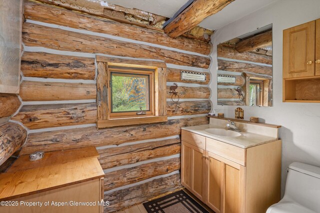 3714 Bear Ridge Rd, Basalt, CO 81621 - bathroom with vanity, beamed ceiling, log walls, and toilet