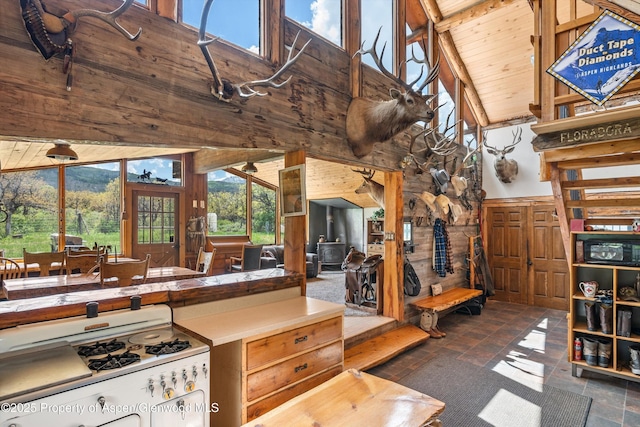 3714 Bear Ridge Rd, Basalt, CO 81621 - kitchen featuring gas range gas stove, high vaulted ceiling, wood walls, stone finish flooring, and wooden ceiling with exposed beams
