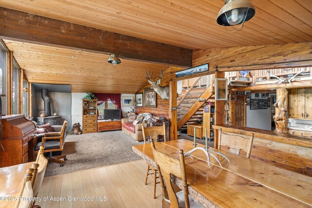 3714 Bear Ridge Rd, Basalt, CO 81621 - dining area with wooden ceiling, a wood stove, wooden walls, hardwood / wood-style flooring, and stairs