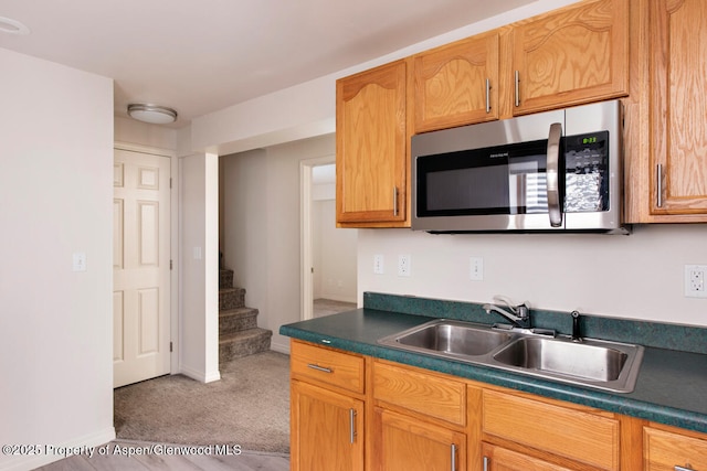 681 S 2nd St Unit A, Carbondale, CO 81623 - kitchen featuring stainless steel microwave, carpet, dark countertops, a sink, and baseboards