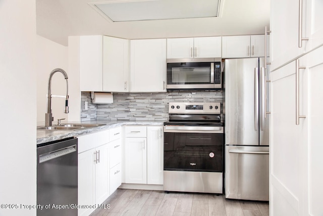 681 S 2nd St Unit A, Carbondale, CO 81623 - kitchen featuring white cabinetry, decorative backsplash, stainless steel appliances, and a sink