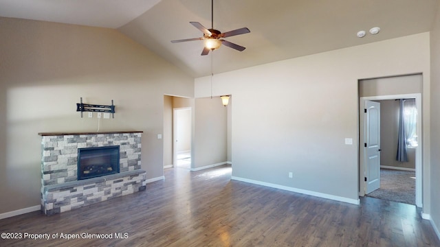 unfurnished living room featuring ceiling fan, a stone fireplace, dark wood-type flooring, and vaulted ceiling