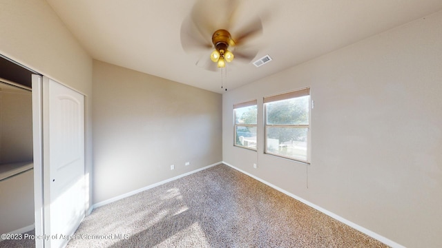 unfurnished bedroom with carpet flooring, ceiling fan, and a closet