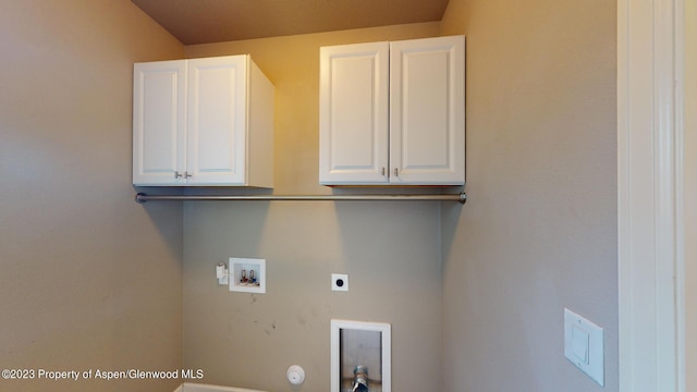 laundry room with hookup for an electric dryer, hookup for a washing machine, hookup for a gas dryer, and cabinets