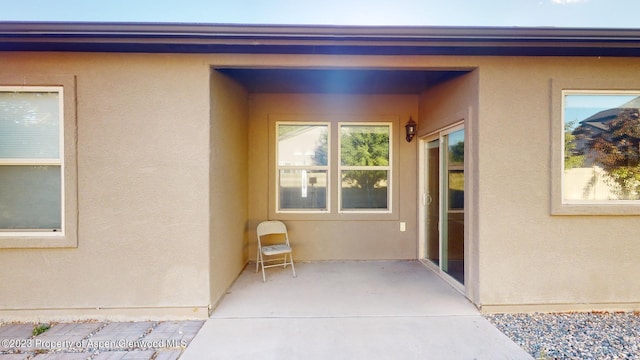 view of exterior entry with a patio