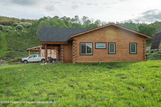 log home with a carport and a front yard