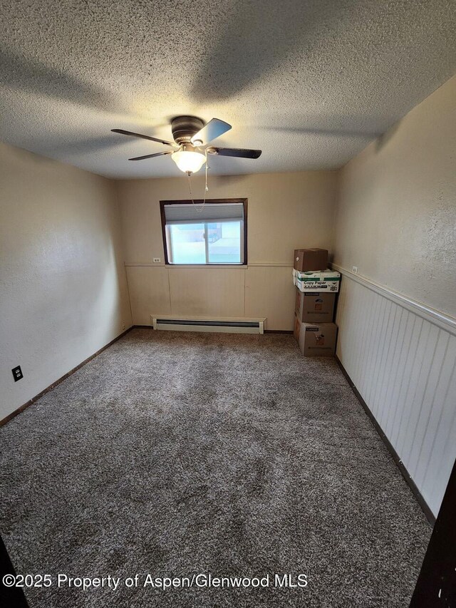 3057 Wellington Ave, Grand Junction, CO 81504 - spare room with baseboard heating, a ceiling fan, carpet, and a textured ceiling