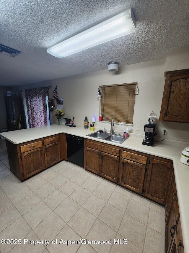 3057 Wellington Ave, Grand Junction, CO 81504 - kitchen featuring dishwasher, a textured ceiling, a peninsula, light countertops, and light tile patterned floors