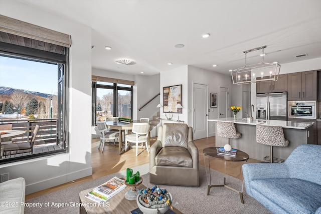 living room featuring a mountain view and light hardwood / wood-style floors