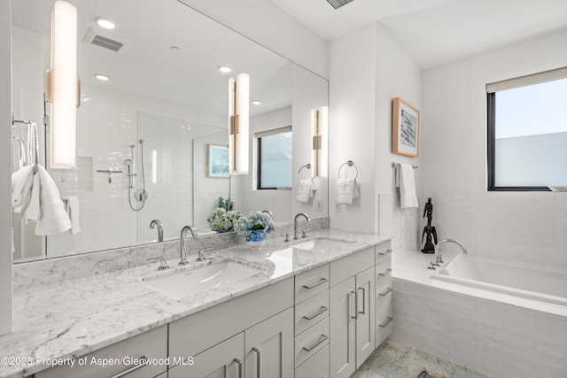 bathroom featuring a wealth of natural light, vanity, and independent shower and bath