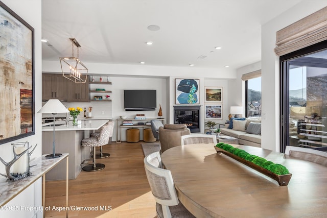 dining room with light hardwood / wood-style flooring and a notable chandelier