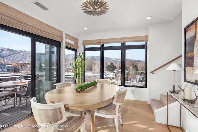 dining area with a mountain view and light hardwood / wood-style flooring