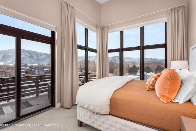 carpeted bedroom with a mountain view and access to exterior