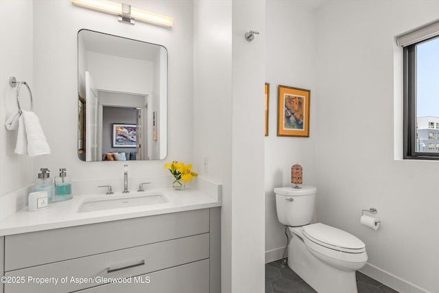 bathroom with tile patterned flooring, vanity, and toilet