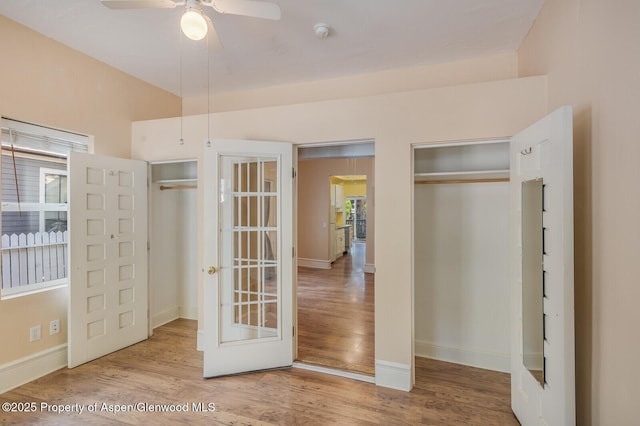 727 Bennett Ave, Glenwood Springs, CO 81601 - unfurnished bedroom featuring wood finished floors, multiple windows, and french doors