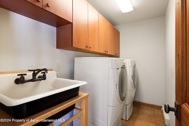 laundry room with washer and clothes dryer, cabinets, and sink